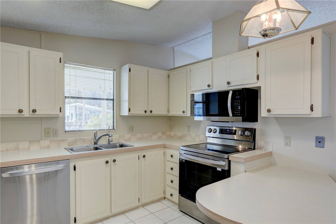 818 Tamarind Circle Sebastian, FL 32976 - Photo 10 of 31 a kitchen with cabinets appliances a sink and a window