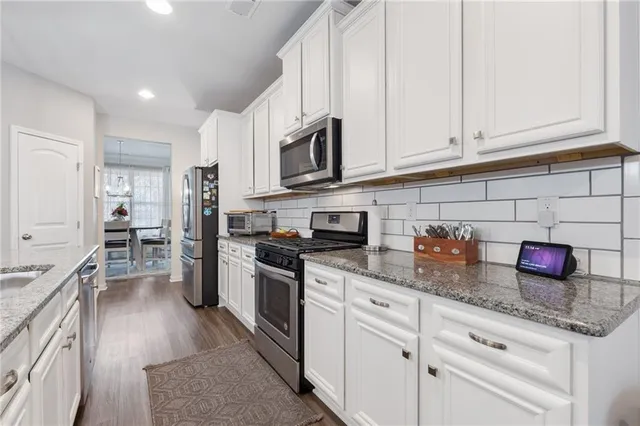 a kitchen with stainless steel appliances white cabinets and a refrigerator