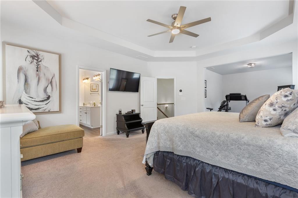 1718 Landon Lane Braselton, GA 30517 - Photo 27 of 52 a spacious bedroom with a bed a couch and a flat screen television