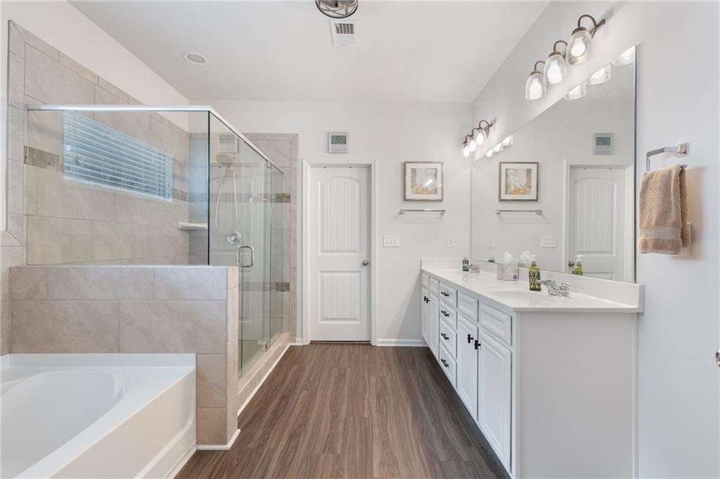 1718 Landon Lane Braselton, GA 30517 - Photo 29 of 52 a bathroom with a double vanity sink a mirror and a bathtub