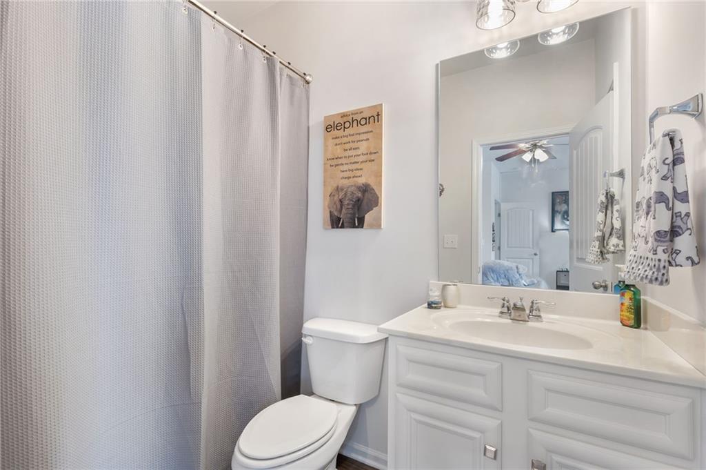 1718 Landon Lane Braselton, GA 30517 - Photo 42 of 52 a bathroom with a sink a toilet a mirror and shower curtain