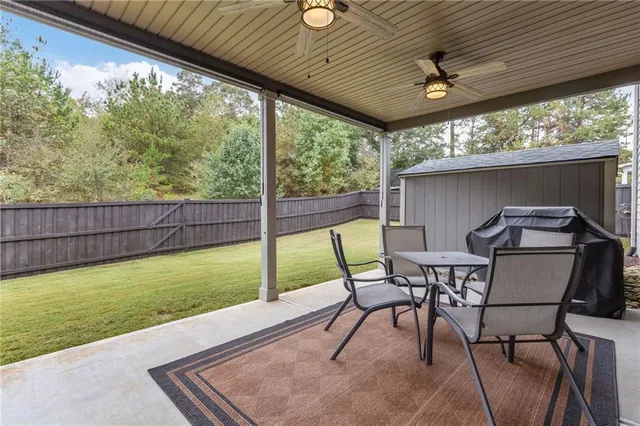 a roof deck with table and chairs and potted plants