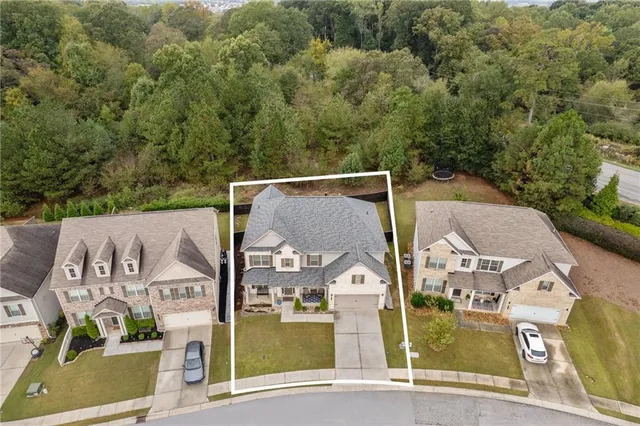 an aerial view of residential houses with outdoor space and parking