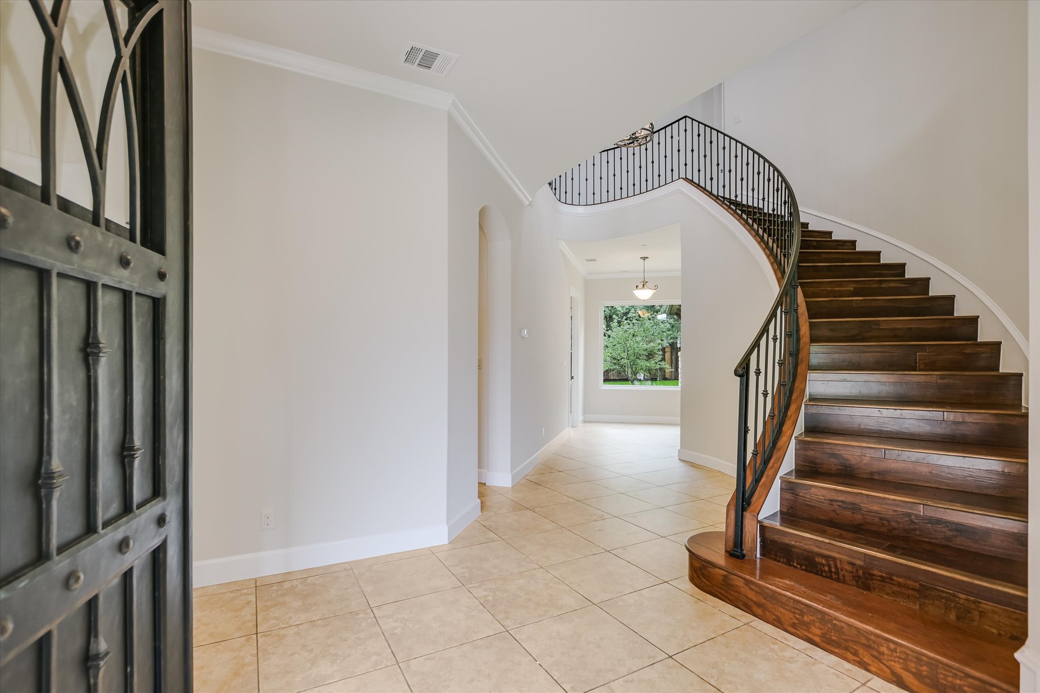 11 Inwood Circle Austin, TX 78746 - Photo 5 of 38 Grand entryway with a sweeping curved staircase and elegant wrought iron accents.
