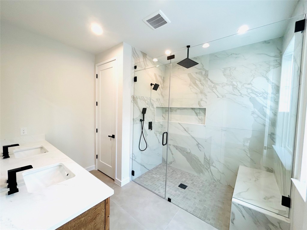 4324 Airport Boulevard, Unit B Austin, TX 78722 - Photo 16 of 22 a bathroom with a sink a mirror and shower