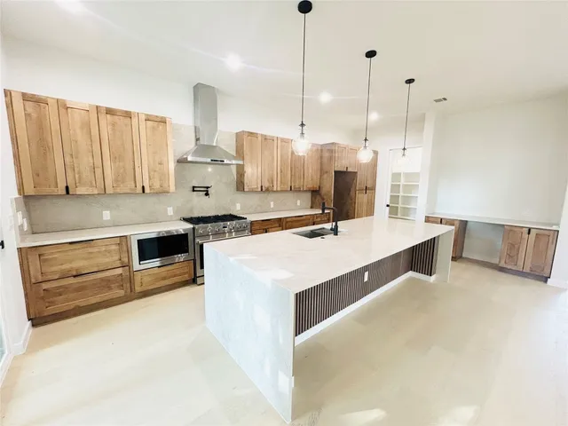 a large kitchen with kitchen island a sink stainless steel appliances and cabinets