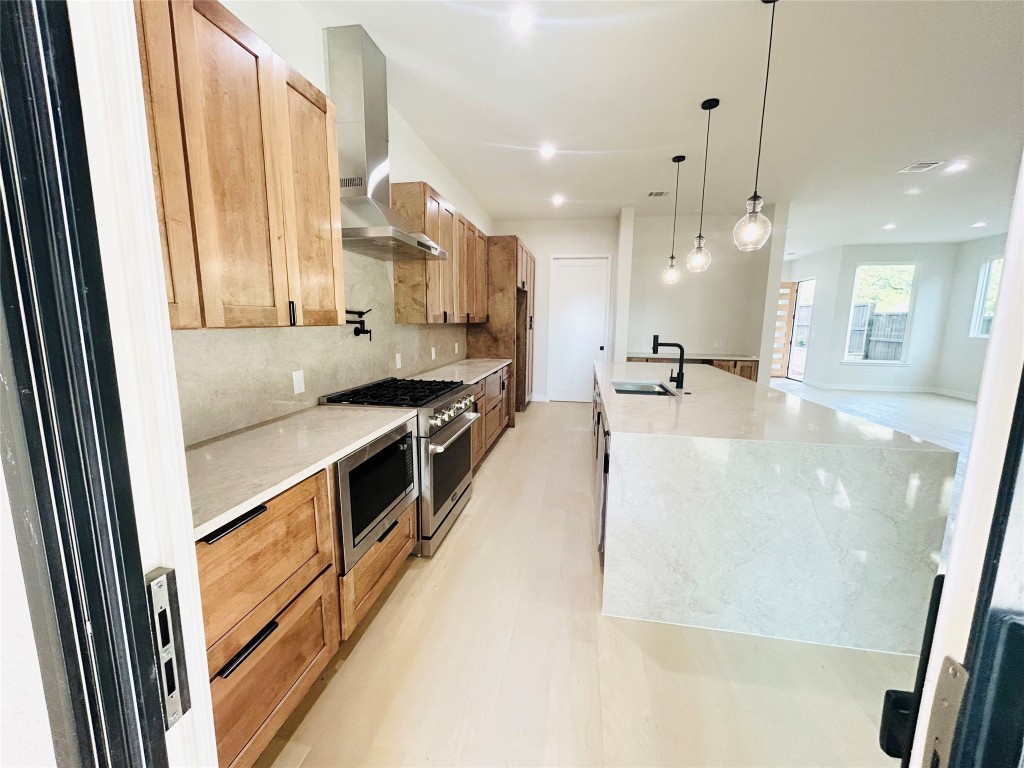 4324 Airport Boulevard, Unit B Austin, TX 78722 - Photo 6 of 22 a kitchen with stainless steel appliances a refrigerator a sink a stove and white cabinets