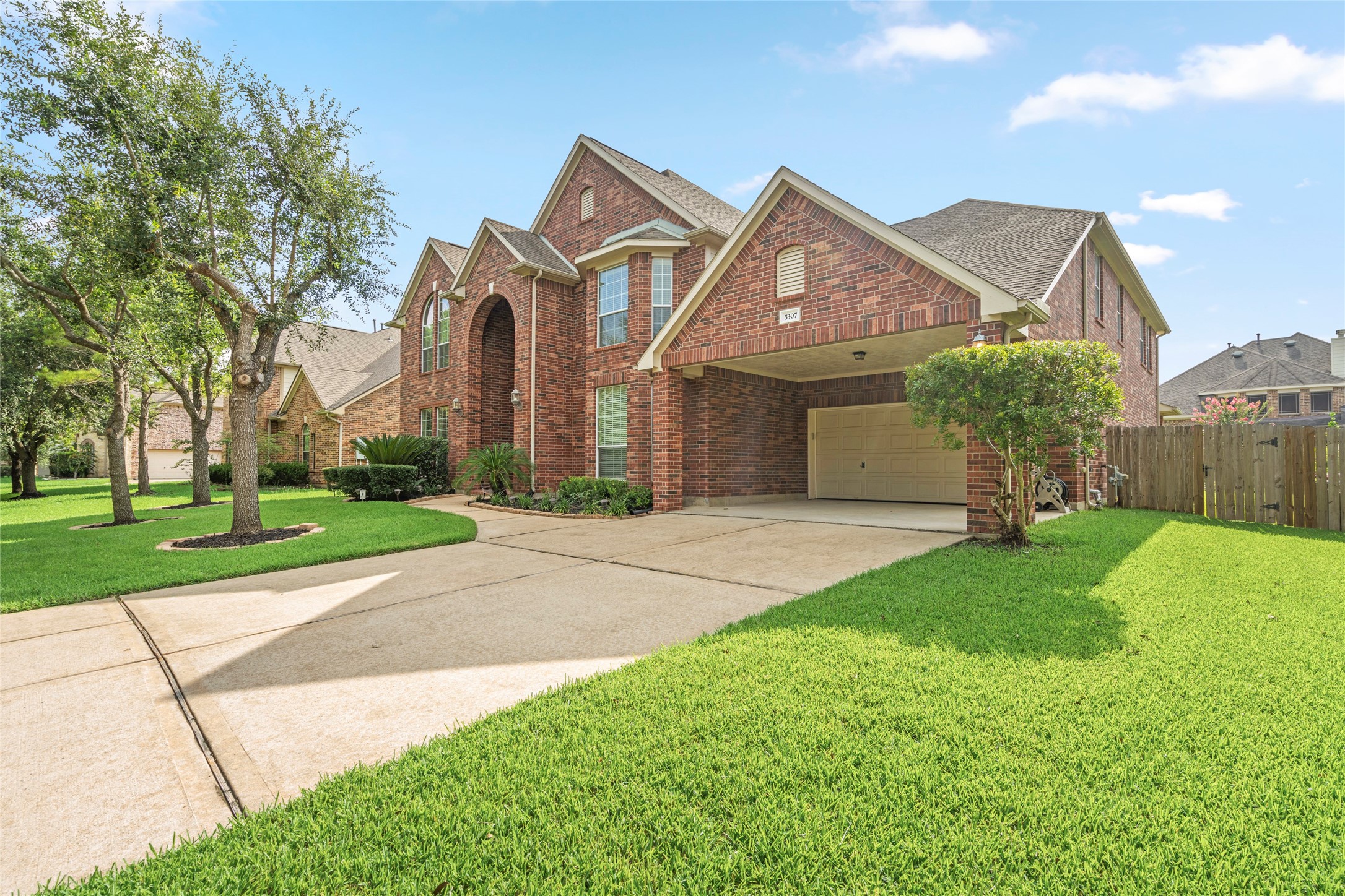 5307 Amber Sky Lane Rosharon, TX 77583 - Photo 2 of 50 An expansive driveway sweeps toward a rare three-car tandem garage with covered carport, offering exceptional space for vehicles, storage, or a home workshop, practicality meets curb appeal.