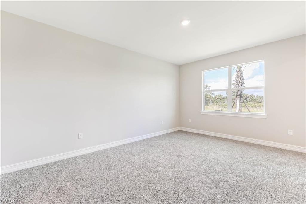 17788 Shade Tree Loop Punta Gorda, FL 33982 - Photo 11 of 44 Carpeted empty room featuring baseboards and recessed lighting
