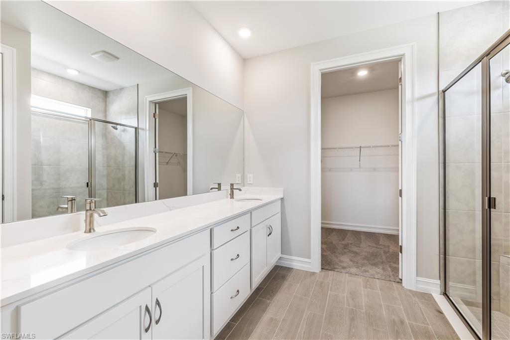 17788 Shade Tree Loop Punta Gorda, FL 33982 - Photo 14 of 44 Bathroom with a spacious closet, a stall shower, wood finish floors, and recessed lighting