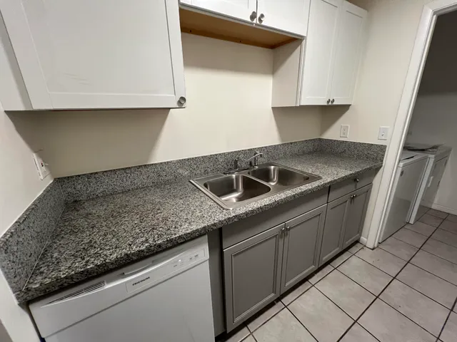 a kitchen with granite countertop a sink and a stove