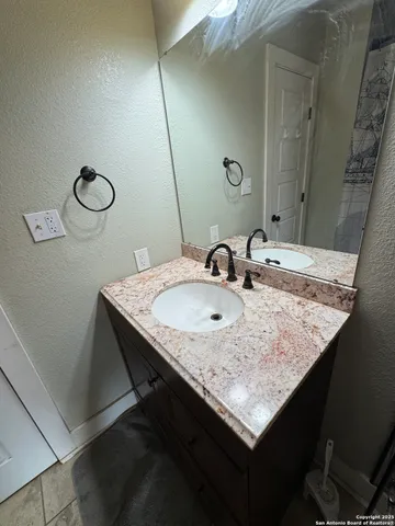 a bathroom with a granite countertop sink and a mirror