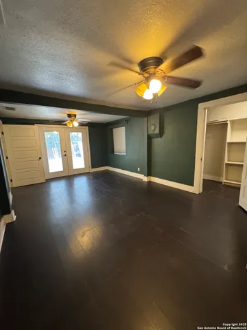 a view of an empty room with window and wooden floor