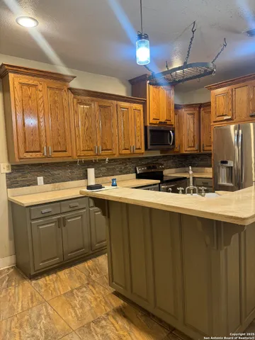 a kitchen with stainless steel appliances granite countertop a stove a sink dishwasher and a microwave oven on the blue kitchen countertops