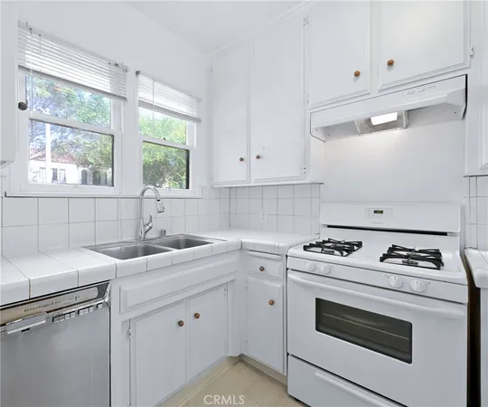 a kitchen with white cabinets and white appliances