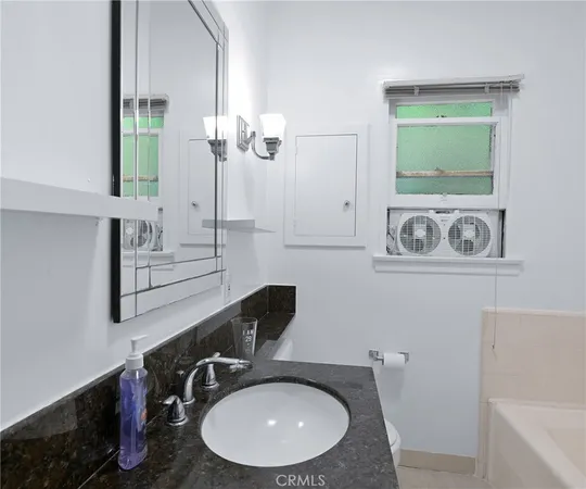 a bathroom with a sink a toilet and mirror