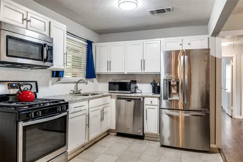 a kitchen with stainless steel appliances a refrigerator sink and microwave