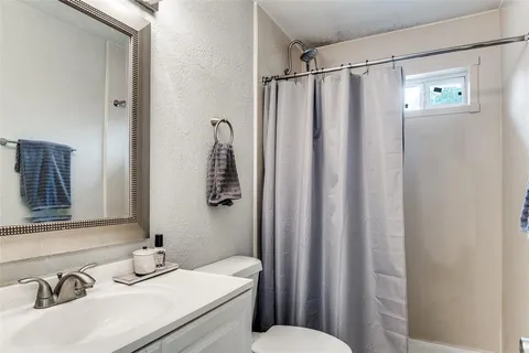 a bathroom with a sink mirror and a toilet