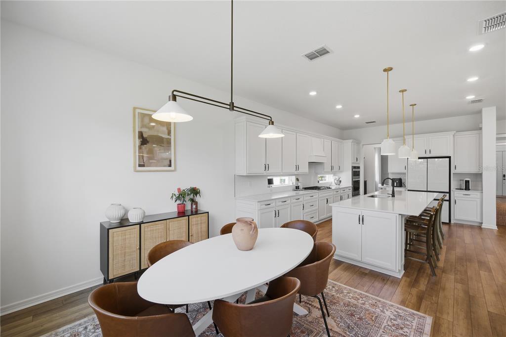 13816 Sharp Hawk Drive Riverview, FL 33569 - Photo 13 of 76 a kitchen with kitchen island a dining table chairs and white cabinets