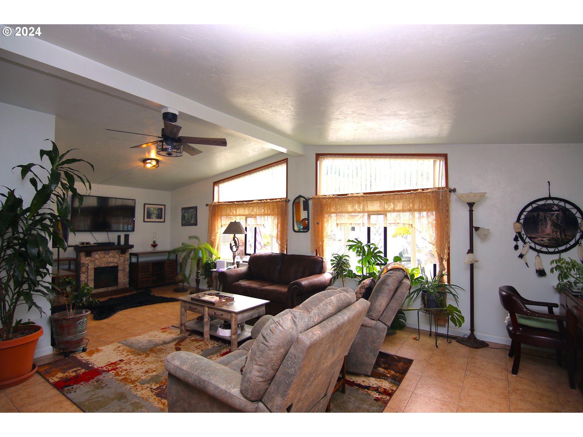 100 River Bend Road, Unit 110 Reedsport, OR 97467 - Photo 3 of 16 a living room with furniture a flat screen tv and a large window