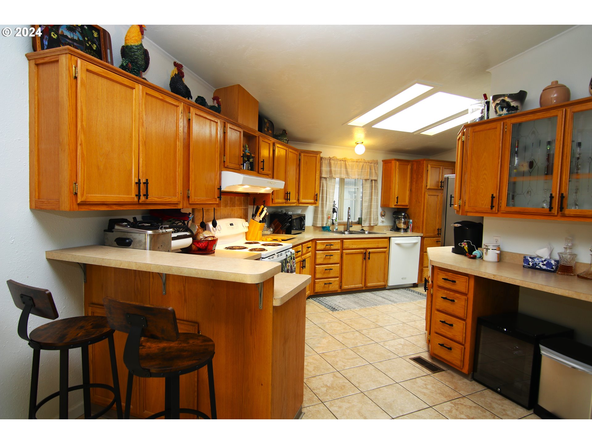 100 River Bend Road, Unit 110 Reedsport, OR 97467 - Photo 5 of 16 a kitchen with stainless steel appliances a sink a stove a refrigerator cabinets and chairs