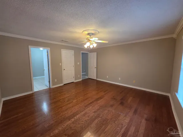 a view of a room with wooden floor and a ceiling fan