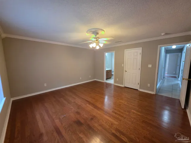 a view of a room with wooden floor and a ceiling fan