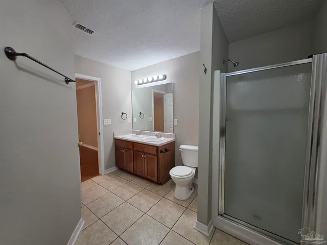 a bathroom with a granite countertop sink toilet a mirror and a shower