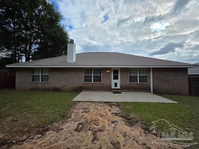 a white house with a big yard and large trees