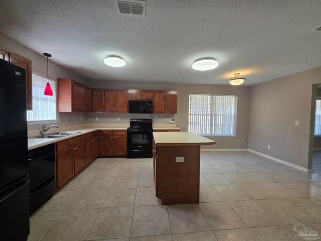 a large kitchen with stainless steel appliances granite countertop a stove and a sink