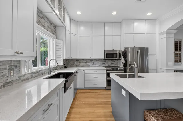 a kitchen with stainless steel appliances granite countertop a sink stove refrigerator and cabinets