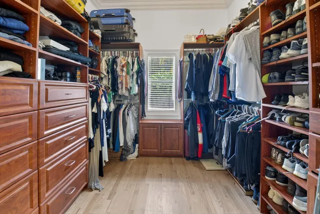 a view of walk in closet with clothes and shoes