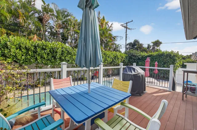 a view of a roof deck with wooden floor and fence with a barbeque grill