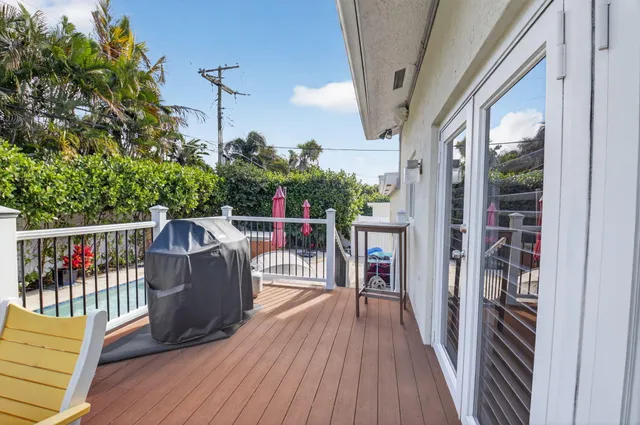 a balcony with wooden floor and outdoor seating