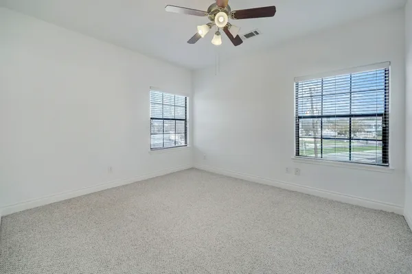 an empty room with a window and a fan