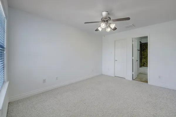 a view of an empty room with a chandelier fan