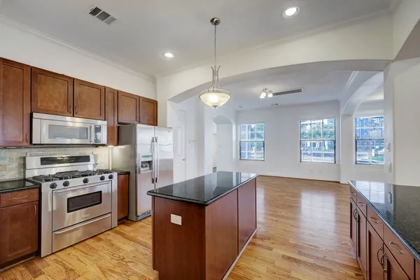 a kitchen with stainless steel appliances granite countertop a sink a stove and a refrigerator