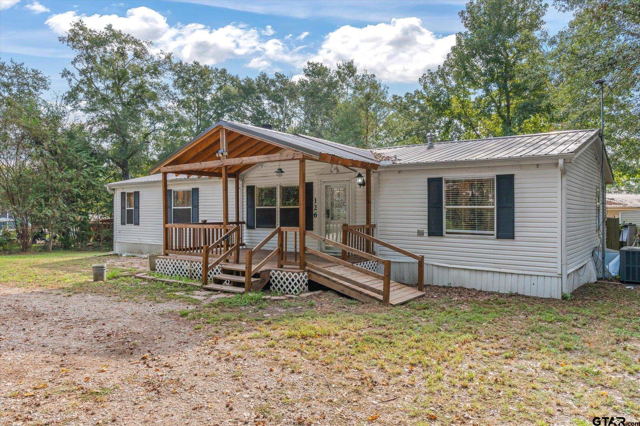 a view of a house with a yard and sitting area