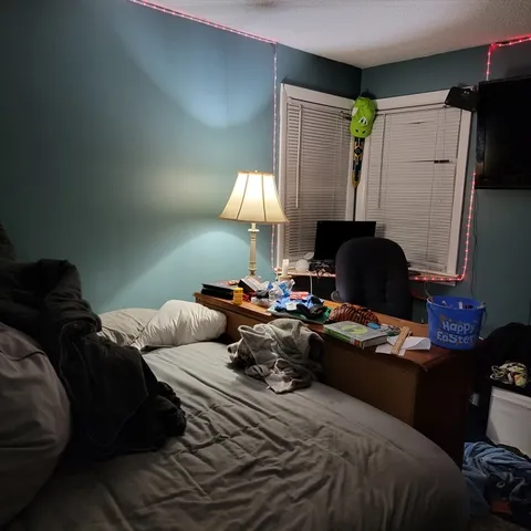 a bedroom with a bed and a computer