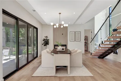 a dining room with wooden floor furniture and a chandelier