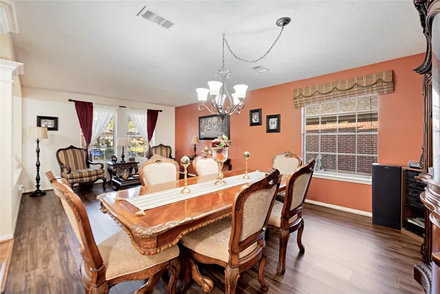 a view of a dining room with furniture a chandelier and wooden floor