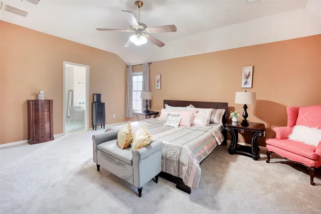 a spacious bedroom with a bed and a chandelier