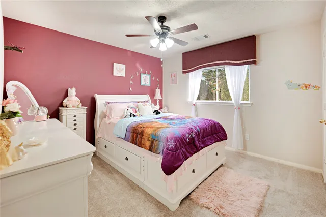 a spacious bedroom with a bed and a ceiling fan
