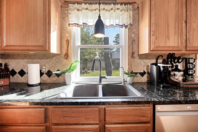a kitchen with granite countertop a sink and a stove