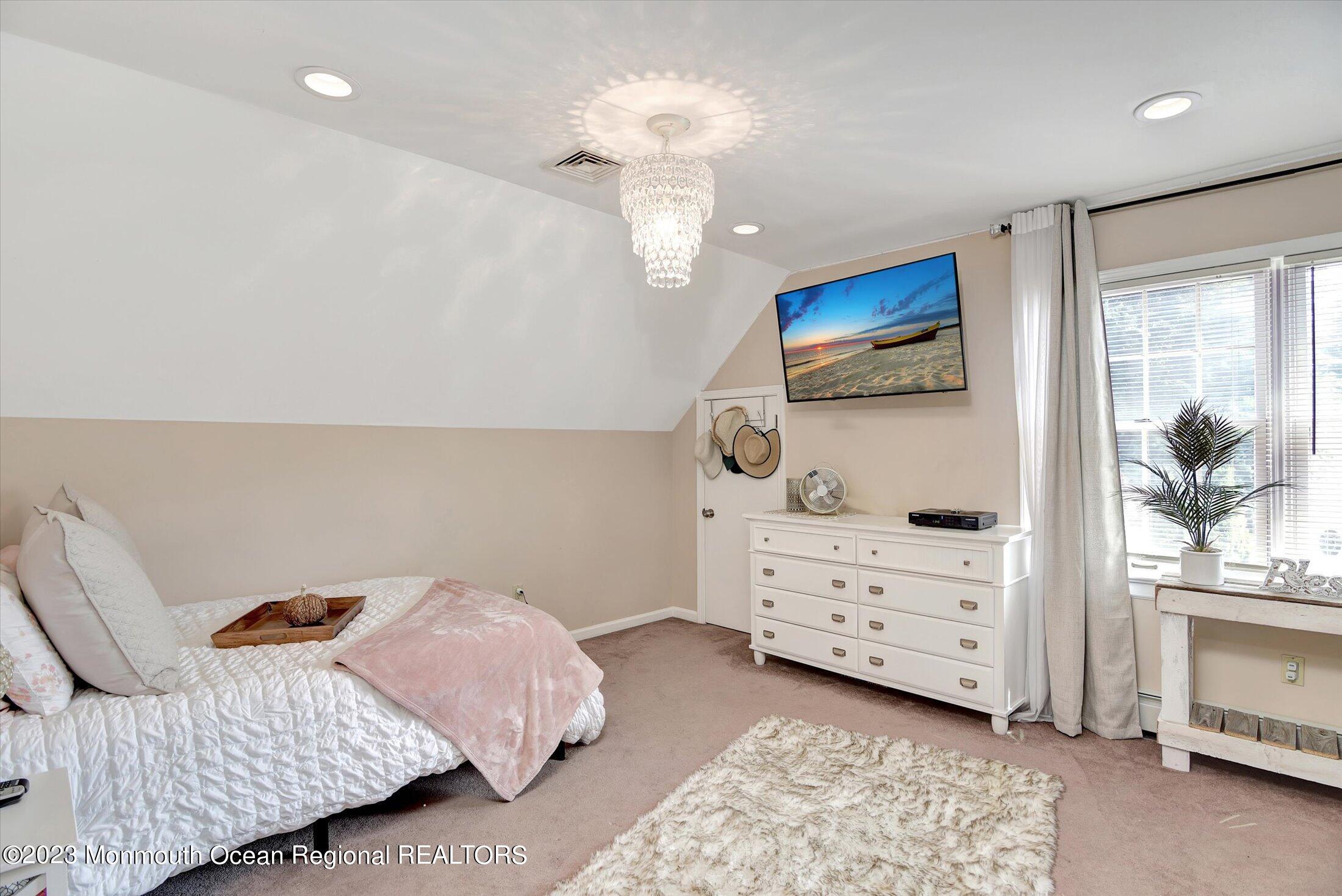 535 Brickyard Road Freehold, NJ 07728 - Photo 11 of 52 a bedroom with a bed and a chandelier