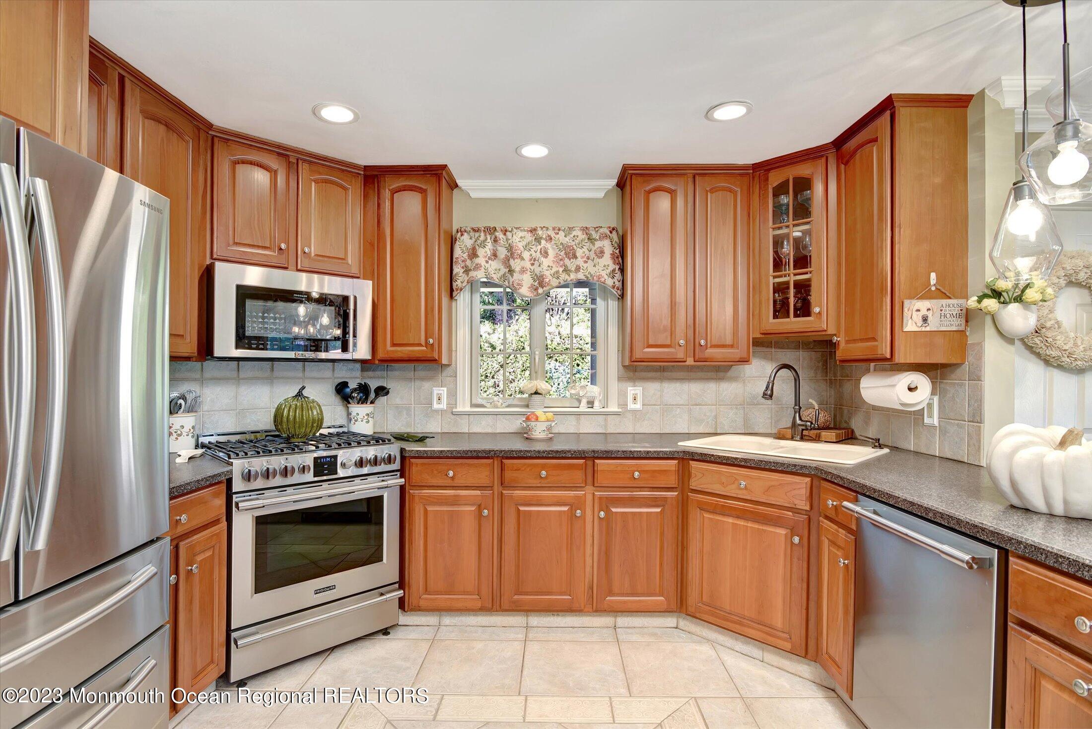 535 Brickyard Road Freehold, NJ 07728 - Photo 5 of 52 a kitchen with stainless steel appliances granite countertop wooden cabinets stove top oven and sink