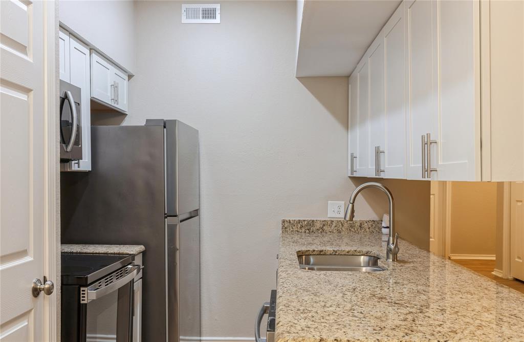 5750 Phoenix Drive, Unit 27 Dallas, TX 75231 - Photo 11 of 19 a kitchen with stainless steel appliances granite countertop a refrigerator a stove and a sink