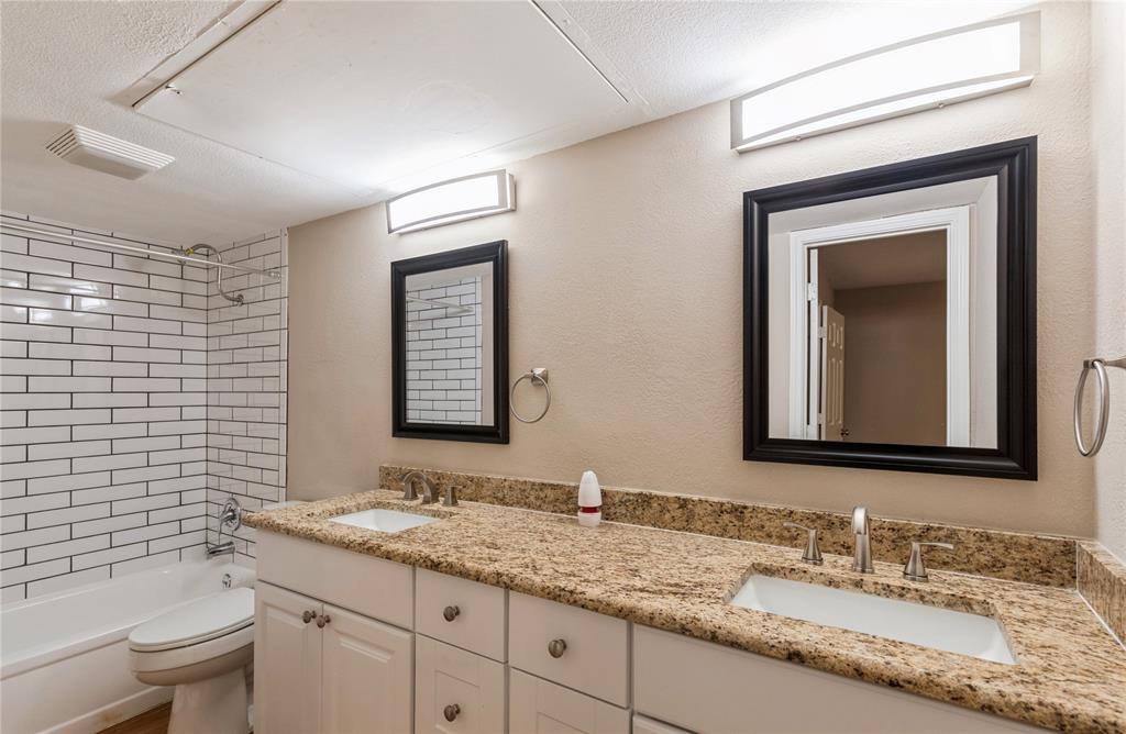 5750 Phoenix Drive, Unit 27 Dallas, TX 75231 - Photo 14 of 19 a bathroom with a granite countertop sink a toilet and mirror