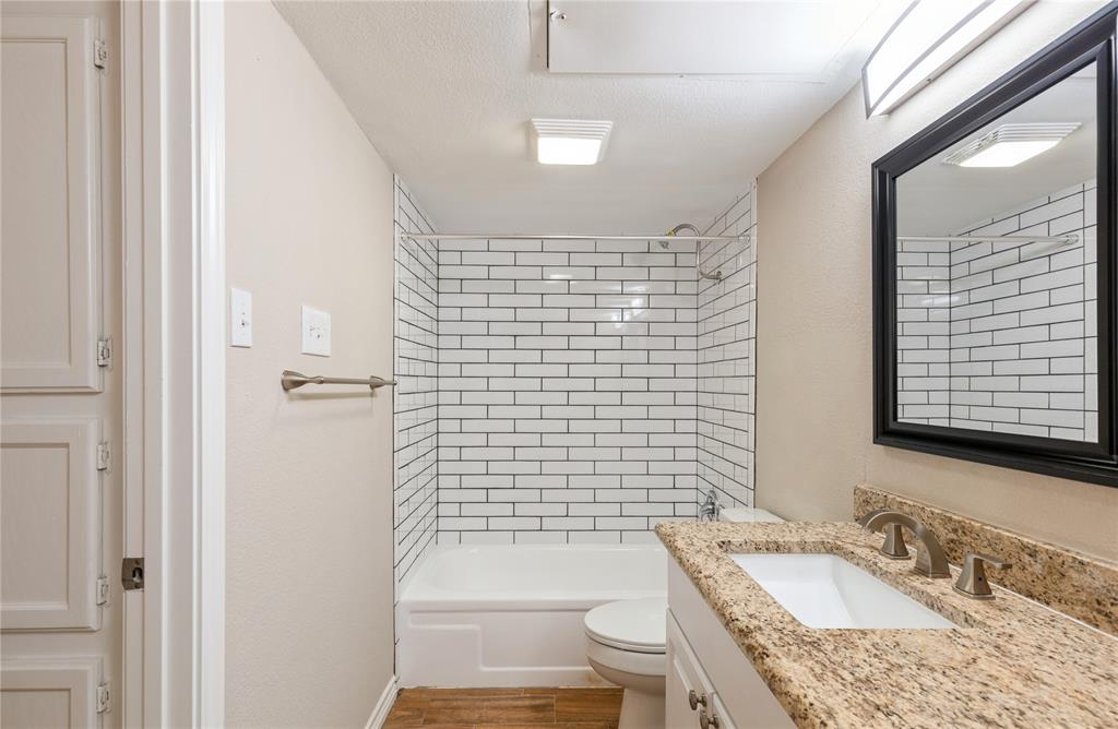 5750 Phoenix Drive, Unit 27 Dallas, TX 75231 - Photo 15 of 19 a bathroom with a granite countertop bathtub sink vanity mirror and toilet