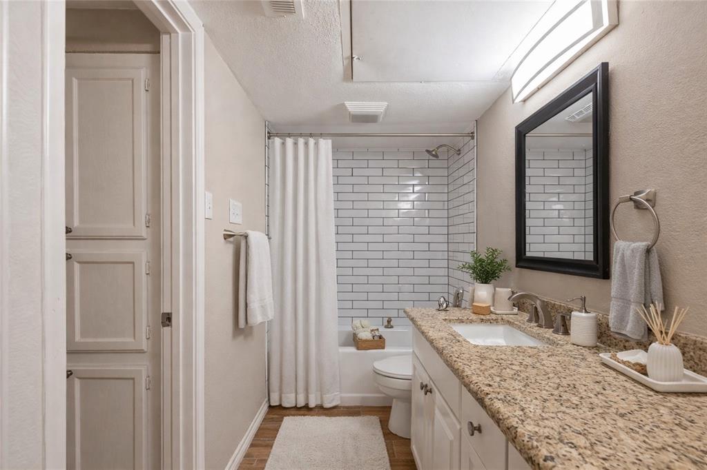 5750 Phoenix Drive, Unit 27 Dallas, TX 75231 - Photo 6 of 19 a bathroom with a granite countertop sink a mirror a vanity and a shower
